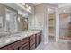 Bathroom features a double vanity with granite countertops, modern fixtures, and a tiled shower with glass door at 7646 Greenwater Cir, Castle Rock, CO 80108