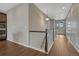 View of a well-lit hallway with hardwood floors, staircase, and neutral paint, leading to various rooms in the home at 7646 Greenwater Cir, Castle Rock, CO 80108