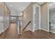 Open hallway with hardwood floors, stairway, and access to a bathroom and living area creating a seamless flow throughout the home at 7646 Greenwater Cir, Castle Rock, CO 80108