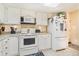 Bright kitchen featuring a full suite of white appliances and ample cabinet storage at 13902 E Marina Dr # 111, Aurora, CO 80014