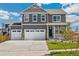 Charming two-story home featuring a three-car garage, manicured lawn, and inviting front porch at 18338 Field Mint Pt, Parker, CO 80134