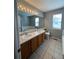 Bathroom with double sinks, large mirror, and tile flooring at 3610 Morning Glory Dr, Castle Rock, CO 80109