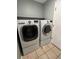 The laundry room contains a modern, front-load washer and dryer set with tile flooring at 3610 Morning Glory Dr, Castle Rock, CO 80109