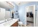 Bathroom features blue walls, updated vanity, toilet, and walk-in closet at 21562 E 47Th Ave, Denver, CO 80249