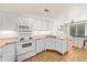 Well-lit kitchen featuring white appliances, ample counter space, and tile flooring at 21562 E 47Th Ave, Denver, CO 80249