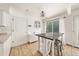 Bright kitchen featuring tile floors, white cabinets, stainless steel stools, and a dining table at 21562 E 47Th Ave, Denver, CO 80249
