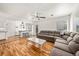 Open living room with wood floors, a gray sectional sofa, and lots of natural light at 21562 E 47Th Ave, Denver, CO 80249