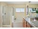 Bathroom featuring double sinks, a bathtub, and a glass-enclosed shower, offering a functional and stylish design at 14025 Blue River Trl, Broomfield, CO 80023