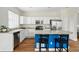 Bright kitchen with white cabinets, stainless appliances, and a blue island with barstool seating at 14025 Blue River Trl, Broomfield, CO 80023