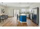 Well-lit kitchen with a blue island, stainless steel appliances, and adjacent to dining and outdoor access at 14025 Blue River Trl, Broomfield, CO 80023