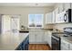 Kitchen featuring white cabinets, stainless appliances, and view to the outside patio at 14025 Blue River Trl, Broomfield, CO 80023
