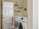 Convenient upstairs laundry room featuring modern appliances and shelving at 14025 Blue River Trl, Broomfield, CO 80023