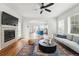 Bright living room featuring a fireplace, ceiling fan, and an open floorplan leading to the kitchen at 14025 Blue River Trl, Broomfield, CO 80023