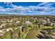 Scenic aerial view of a community with lush greenery, ponds, and mountain views in the distance at 4273 W Ponds Cir, Littleton, CO 80123