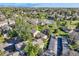 Expansive aerial view of a neighborhood featuring townhomes, a pond, and lush greenery, offering a serene living environment at 4273 W Ponds Cir, Littleton, CO 80123