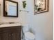 Bathroom features dark vanity, granite countertop, toilet, mirror and modern fixtures at 4273 W Ponds Cir, Littleton, CO 80123