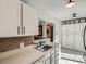 Bright kitchen with white cabinets, tiled backsplash, and modern appliances at 4273 W Ponds Cir, Littleton, CO 80123