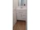 Stylish bathroom featuring a modern white vanity with sleek hardware and a decorative mirror, complemented by wood flooring at 5319 Morning Glory Pl, Highlands Ranch, CO 80130