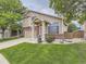 Charming two-story home with brick accents, attached garage, landscaped yard, and neutral siding at 5319 Morning Glory Pl, Highlands Ranch, CO 80130
