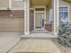 Inviting front entrance with brick accents, covered porch, well-manicured landscaping, and attached garage at 5319 Morning Glory Pl, Highlands Ranch, CO 80130