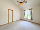 Cozy bedroom features neutral carpet, ceiling fan, and natural light from the large window at 3231 E 102Nd Pl, Thornton, CO 80229