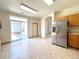 Spacious kitchen leading to a patio, stainless steel fridge and tile flooring at 3231 E 102Nd Pl, Thornton, CO 80229