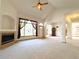 Bright living room showcasing a fireplace, vaulted ceilings, large windows, and plush carpet at 3231 E 102Nd Pl, Thornton, CO 80229