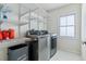 Efficient laundry room with wire shelving and modern front load washer and dryer set for added convenience at 2831 Spruce St, Denver, CO 80238