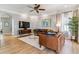 Bright living room featuring hardwood floors, ceiling fan, stylish furniture, and a modern television at 2831 Spruce St, Denver, CO 80238