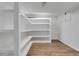 Basement storage area with white shelving units and hardwood floors ready for customization at 3653 E 133Rd Ct, Thornton, CO 80241