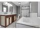 Bright bathroom with a modern vanity, soaking tub, and glass-enclosed shower providing a luxurious experience at 3653 E 133Rd Ct, Thornton, CO 80241