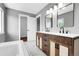 Bathroom featuring double sink vanity, two modern mirrors, and a soaking tub at 3653 E 133Rd Ct, Thornton, CO 80241