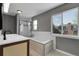 Bright bathroom featuring double vanity, a soaking tub, and a glass shower with gray walls at 3653 E 133Rd Ct, Thornton, CO 80241