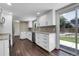 Bright kitchen with white cabinets, stainless appliances, granite countertops and hardwood floors at 3653 E 133Rd Ct, Thornton, CO 80241