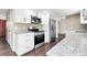 Updated kitchen featuring white cabinets, granite countertops, stainless steel appliances, and hardwood floors at 3653 E 133Rd Ct, Thornton, CO 80241
