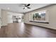 Spacious living room showcasing hardwood floors, large picture window, and open layout to the kitchen at 3653 E 133Rd Ct, Thornton, CO 80241