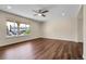 View of empty living room featuring wood floors, ceiling fan, and a large window at 3653 E 133Rd Ct, Thornton, CO 80241