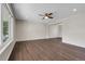 View of empty living room featuring wood floors, ceiling fan, and a large window at 3653 E 133Rd Ct, Thornton, CO 80241