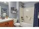 A well-lit bathroom includes a shower and tub combination, along with a vanity and toilet with a blue painted wall at 5671 Raleigh Cir, Castle Rock, CO 80104