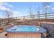 Inviting hot tub area with wood deck, stone landscaping, and a wooden fence offering a private and relaxing outdoor space at 5671 Raleigh Cir, Castle Rock, CO 80104