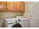 This laundry room features side by side washer and dryer and wood upper cabinets at 5671 Raleigh Cir, Castle Rock, CO 80104