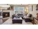 Bright living room featuring fireplace, plush seating, and backyard views at 5671 Raleigh Cir, Castle Rock, CO 80104