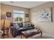 A cozy living room featuring a leather sofa, decorative throw pillows, an attractive coffee table, and a serene window view at 5671 Raleigh Cir, Castle Rock, CO 80104
