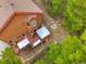 An aerial view shows the house with wooden deck, lounge furniture, fire pit, and mature trees on the property at 322 Davis Ct, Breckenridge, CO 80424