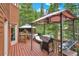 Inviting outdoor deck featuring a grill, lounge furniture, and canopies, perfect for relaxing or entertaining with a forest backdrop at 322 Davis Ct, Breckenridge, CO 80424