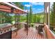 Outdoor deck area with a gazebo, grill, seating, and scenic views of the surrounding landscape at 322 Davis Ct, Breckenridge, CO 80424