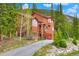 Exterior view of the home with beautiful wood siding that is surrounded by mature trees at 322 Davis Ct, Breckenridge, CO 80424