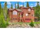 Beautiful two-story home with a red roof, stone accents, and lush landscaping, offering a warm and inviting curb appeal at 322 Davis Ct, Breckenridge, CO 80424