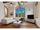 Bright living room with vaulted ceilings, wood beams, and mountain views from the beautiful, large picture windows at 322 Davis Ct, Breckenridge, CO 80424
