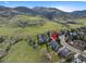 Aerial view of house in green neighborhood near mountains with a cul-de-sac at 87 Deerwood Dr, Littleton, CO 80127